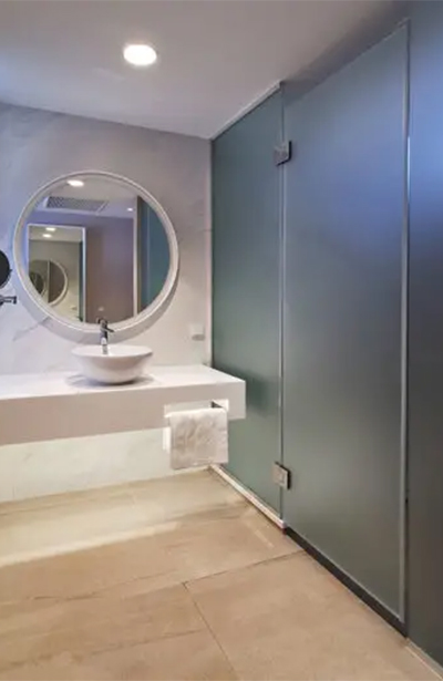 Baño con encimera de mármol, lavabo sobre encimera y espejo redondo en el Hotel Castillo de Peñíscola Spa 4* Sup
