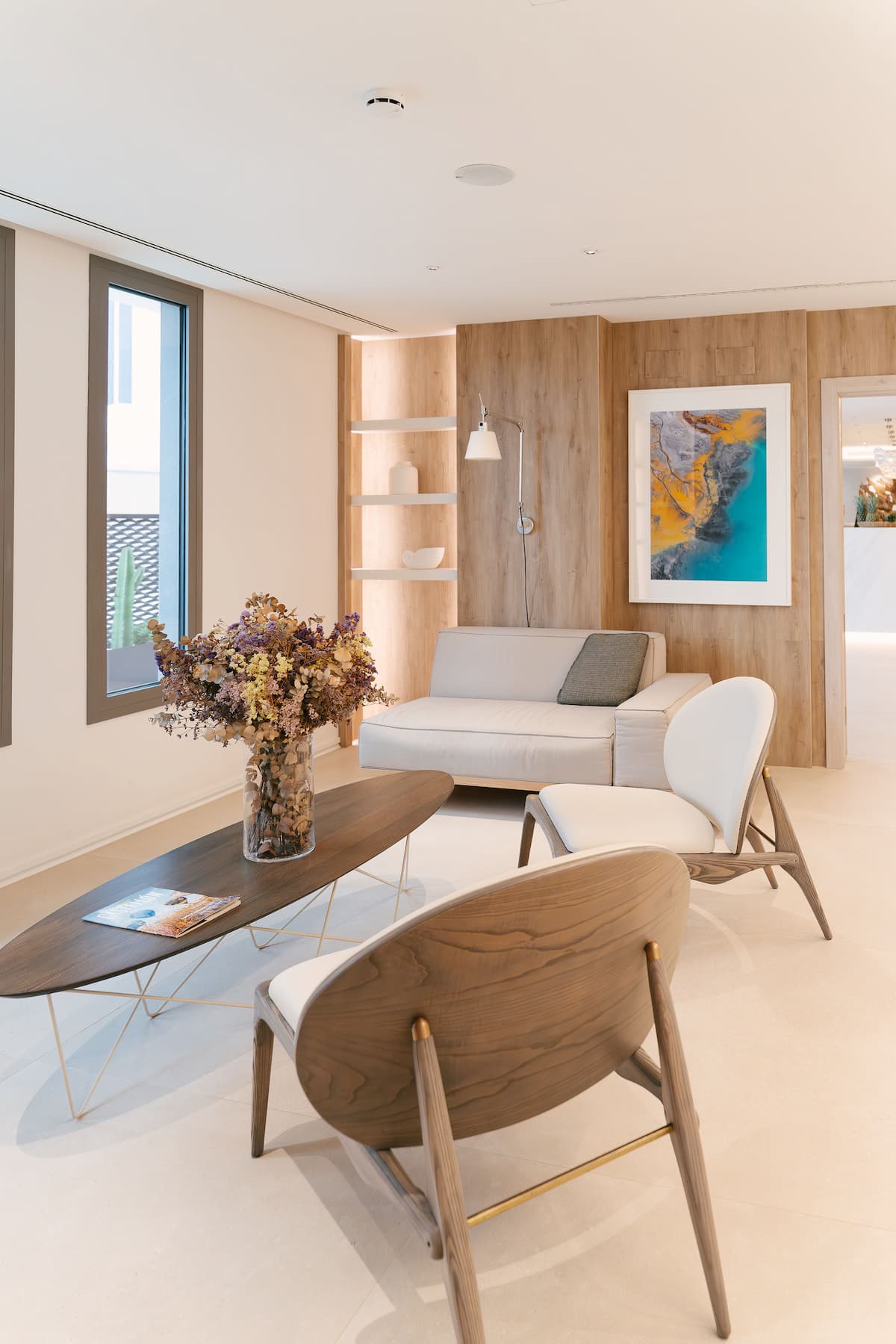 Sala de Lectura del Hotel Castillo de Peñíscola con sofá, lámpara articulada y obra abstracta