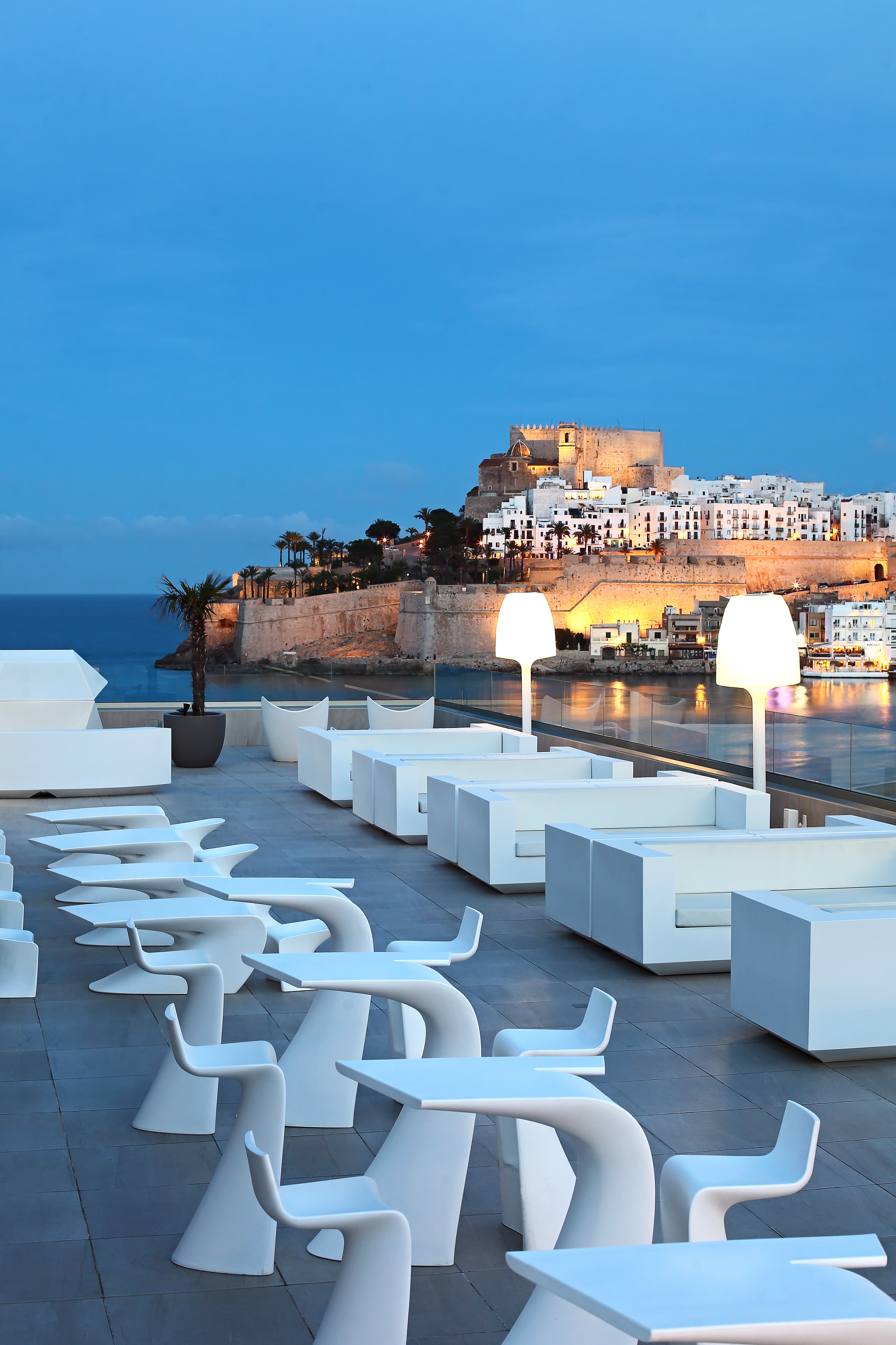 Terraza chill out del Hotel Castillo de Peñíscola al atardecer con vistas al Castillo del Papa Luna iluminado